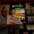 El propietario del bar Las Eras de Camponaraya mostrando el cartel del número premiado