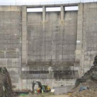Unos obreros trabajan a los pies de la presa de Villagatón, en el acondicionamiento de las instalaci