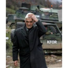 Un anciano albanés pasa por delante de un destacamento de la KFOR