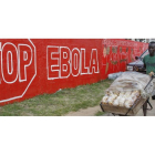 Un hombre pasa junto a un gran cartel del ébola en Monrovia