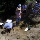 Una voluntaria de la asociación recupera restos de la fosa de Pardamaza