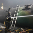 Un bombero apaga el fuego en una nave industrial en Villamañán.