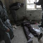 Policías afganos inspeccionan el cadáver de un talibán, en un edificio de Kabul, este lunes.