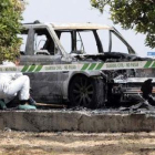 La Guardia Civil recoge pruebas en el coche calcinado.