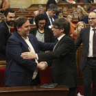 Junqueras y Puigdemont se saludan en el Parlament, en marzo.