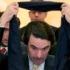 El ex presidente del Gobierno, José María Aznar, se quita la bufanda en un acto público