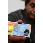 El padre del niño muestra el carné de identidad del pequeño, expedido en España