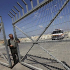 Un trabajador palestino abre una verja en un puesto fronterizo entre Israel y la Franja de Gaza.