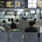 Varios pasajeros esperan la llegada de sus trenes ante las pantallas informativas, esta mañana en la estación de Chamartín, en Madrid.