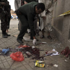 Un policía yemení inspecciona restos del atentado suicida.