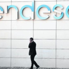 Un hombre camina bajo el logo de Endesa en la sede de la empresa en Madrid.