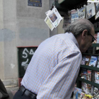 Un hombre mayor lee la prensa en un kiosco