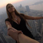 Viki Odintcova, de la mano de su asistente, sin arnés, a 300 metros de altura, a punto de hacerse un selfi de vértigo.