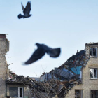 Unas palomas vuelan frente a los restos de un bloque de casas en la ciudad ucraniana de Bajmut. OLEG PETRASYUK