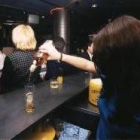 Una camarera sirve una copa en un bar de la capital leonesa