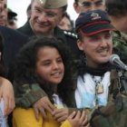 El sargento del Ejército Arlbey Delgado abraza a sus hijas mientras habla con los medios.