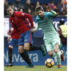 Messi intenta escaparse de la defensa de Causic. El argentino anotó dos goles frente a Osasuna. DIGES
