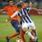 El jugador del Recreativo de Huelva Jesús Vázquez escapa entre Angulo y Villa