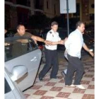 El presunto asesino (d) durante su traslado a la Comisaría de Ceuta