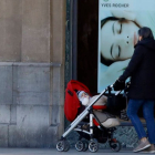 Una mujer paseando a un bebé en las calles de León. MARCIANO PÉREZ