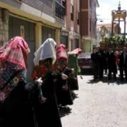 Las maragatas se inclinan ante la Cruz Dorada durante la procesión