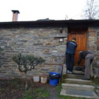 Dos operarios arreglaban ayer tarde la puerta de la vivienda asaltada en Penoselo.