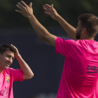 Messi conversa con Piqué durante el entrenamiento del Barcelona.
