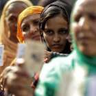 Varias mujeres hacen cola en un colegio electoral durante la segunda fase de las elecciones para la Asamblea estatal de Gujarat, en Ahmedabad (India), el 14 de diciembre.