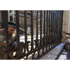 Dos trabajadores pintan las rejas de la Catedral