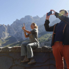 Dos turistas fotografían el imponente paisaje de Picos de Europa en León. JESÚS F. SALVADORES