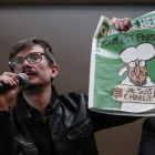 Un caricaturista sostiene la portada de ‘Charlie Hebdo’.