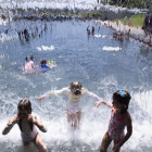Niños bañándose ayer en un parque de un barrio de Washington. MICHAEL REYNOLDS