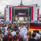 Simpatizantes de la selección nacional alemana de fútbol siguen por televisión la salida de los jugadores de Brasil en la llamada "Milla del aficionado" en la Puerta de Brandeburgo en Berlín.