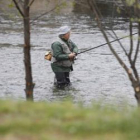 Un pescador perfectamente ataviado lanza la caña en las aguas del río Órbigo a la altura de Hospital