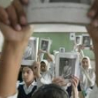 Escolares iraquíes portan retratos de Sadam en el colegio.