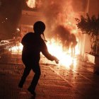 Un manifestante lanza un cóctel molotov a la policía en Atenas.
