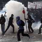Centenares de manifestantes se enfentan a agentes de la policía antidisturbios frente al Parlamento griego en Atenas hoy.