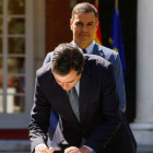 Pedro Sánchez detrás de Garamendi ayer en la Moncloa durante la firma del pacto de pensiones. BALLESTEROS