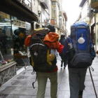 Dos peregrinos caminan por la calle de La Rúa en la capital.