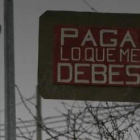 La morosidad está en la calle como refleja el cartel colocado en un pueblo muy cercano a Ponferrada