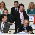 José María Aznar pasa por el lado de Mariano Rajoy, sentado junto a Manuel Fraga, en la clausura del XVI congreso nacional del PP, en el 2008 en Valencia
