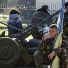 Un efectivo ucraniano sostiene una bandera de Ucrania mientras fuma en una base militar en la ciudad crimea de Belbek, cerca de Sebastopol.
