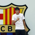 Neymar posa para los medios de comunicación ante el escudo azulgrana, en la entrada principal de las oficinas del Barça.