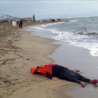 Un miembro de los equipos de rescate contempla el cuerpo de un inmigrante sobre la playa en Ayvalink (Turquía).