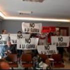 Un grupo de asistentes al pleno exhibieron pancartas contra la guerra