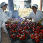 Dos mujeres dan vuelta a los pimientos durante la fase de asado del producto.