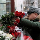 Un soldado ruso deposita flores en un pequeño altar montado ante la sede del Alexandrov Ensemble (El coro del Ejército Rojo) en Moscú (Rusia) ayer, 26 de diciembre de 2016.