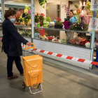 Una mujer espera su turno para ser atendida en un puesto de venta permanente de un mercado de abastos en Lugo. ELISEO TRIGO