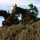 Dos caballos con sus respectivos jinetes saltan un obstáculo en el Grand National de Aintree, en el 2009.