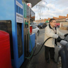 Un hombre reposta su vehículo en una gasolinera.